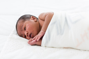 Obraz na płótnie Canvas Newborn baby or Infant lying in blanket on white bed. African American newborn baby. Afro infant