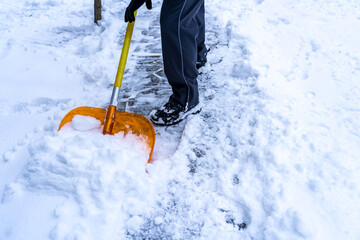 Snow removal by hand from a walking path in winter with a shovel