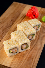 Close up of mouthwatering warm shrimp and avocado sushi roll set on wooden board