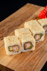 Close up of mouthwatering warm shrimp and avocado sushi roll set on wooden board