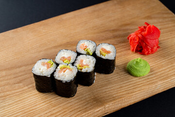 Classic cucumber and lettuce sushi rolls on wooden board, six rolls set on board