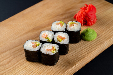 Classic cucumber and lettuce sushi rolls on wooden board, six rolls set on board