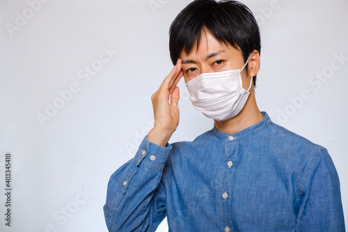 マスクをして頭を押さえる男性 風邪 偏頭痛 Wall Mural Rummy Rummy