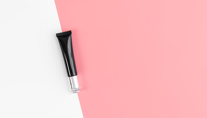 Black bottle cream, mockup of beauty product brand. Top view on the pink background.