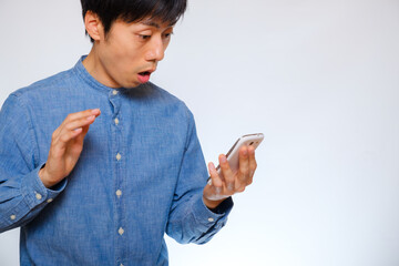 スマホを見て驚く男性