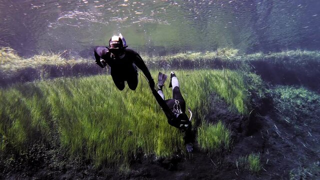 Professional snorkeler helps a diver to ascend. 