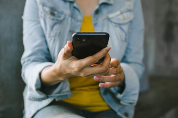 using cell phone hand holding mobile texting message contact us.chatting,search internet information in office.technology device communication connecting