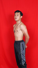 asian man bodybuilder isolated red background
