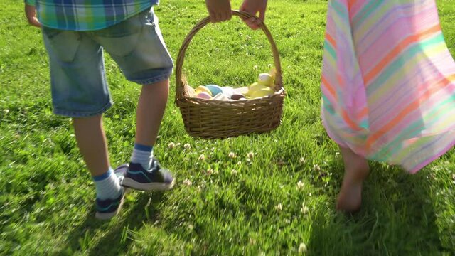 Two children boy and girl having easter egg hunt in garden backyard