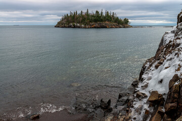 Fototapeta na wymiar Island with coniferous trees and orange moss near lake Superior