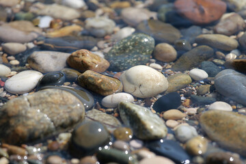 small sea pebbles in the water. Smooth stones