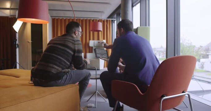 Business team in colourful startup having a meeting with iPad