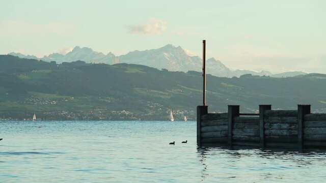 Man in Kayak crossing Bodensee in front of mountains