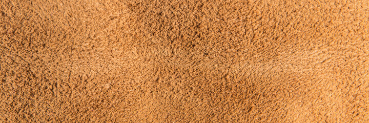 leather grunge background: an old piece of tough camel skin, with scuffs, spots, scars