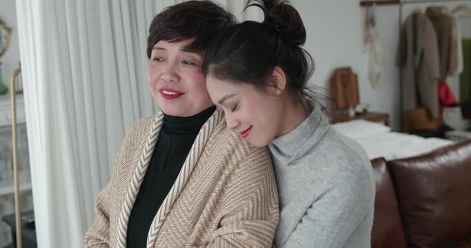 Happy moments  Intimate relationship between mother and adult daughter Young woman put her arms around her mother and leaned her head on shoulder 