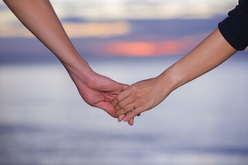 couple holding hand walking near the beach