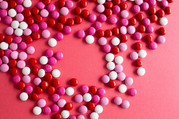 pink, white, and red chocolage candies on a red background
