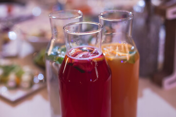 View of alcohol setting on catering banquet table, row line of different colored alcohol cocktails on a party, martini, vodka, spritz and others on decorated catering table event