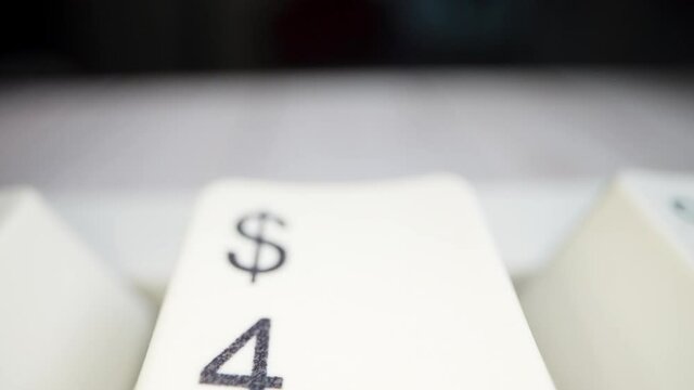 White keyboard dollar sign. Camera movement from left to right. Macro footage.