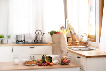 Shopping bags with healthy food are placed on the kitchen table, grocery shopping concept