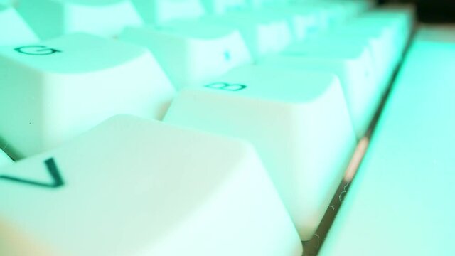 White keyboard keys with Colourful Purple Neon. Macro photography.