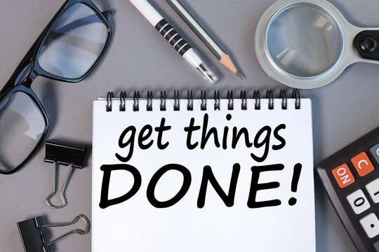 Get Things Done. text in a notebook on a gray background near a magnifier, calculator. business concept