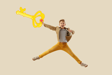Jumping little boy with drawn golden key on light background