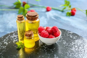 Bottles of raspberry essential oil on table