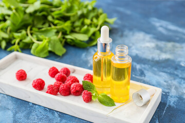 Bottles of raspberry essential oil on table