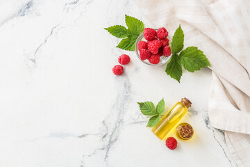 Obraz na płótnie Canvas Bottles of raspberry essential oil on light background