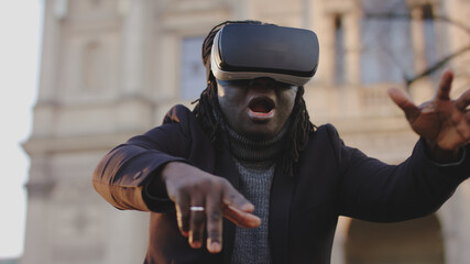 Scared african american man with VR headset gesturing like in free fall. High quality photo