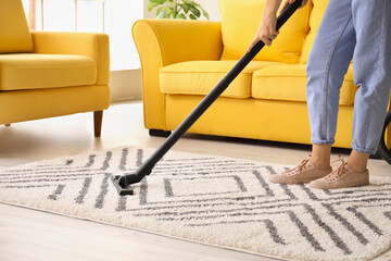 Woman cleaning beautiful carpet in living room