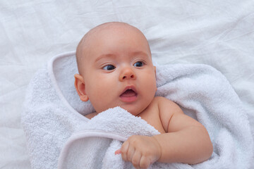 Baby wrapped in white dress after bathing