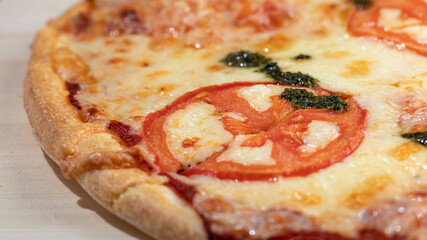 pizza margarita with pesto sauce on wooden board, close up, selective focus