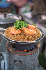 Baked shrimp with glass noodles on charcoal stove with soft focus and noise.