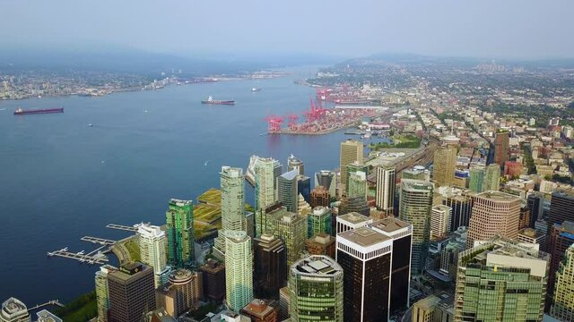 Panning drone shot of downtown Vancouver showing most of downtown and the harbour all the way over to Stanley Park.