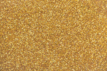 Surface made of gold fine crumbly glitter. Gold glitter background.