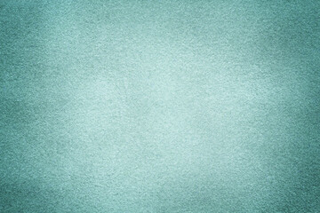 Blue matte background of suede fabric with vignette, closeup. Velvet textile.
