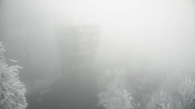 Predikaloszek lookout among winter frosty forest trees.