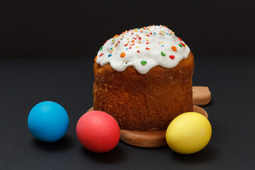 Easter cake and colorful Easter eggs in black background.