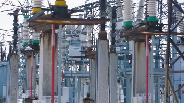Many power poles in substation. Action. Electric substation with powerful equipment and transformers working in winter. Winter clear day at electric power station