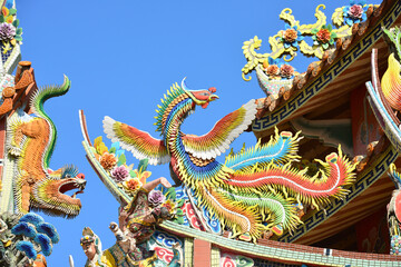 Fototapeta na wymiar Traditional Chinese Ceramic bird sculpture on temple roof