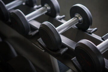 Fototapeta na wymiar dumbbells in the gym at sports club for exercise and Bodybuilding