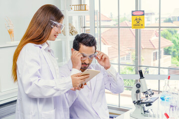 Fototapeta premium Doctor and microbiologist with vacuum tubes for samples with COVID 19 infection atypical pneumonia virus in laboratory