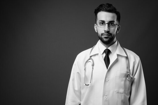 Young handsome bearded Iranian man doctor shot in black and white