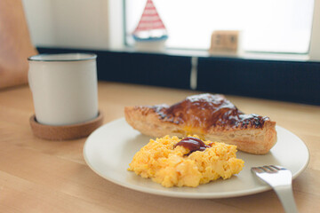 Breakfast set of homemade sandwich pie with scrambled egg and black coffee.
