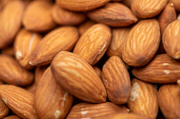 Almonds scattered on the table. Close-up, selective focus.