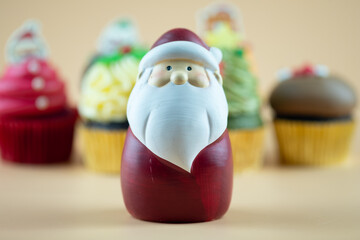 Santa costa standing in front of cupcake. Concept of Santa is coming to town