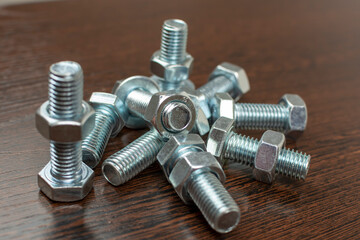 fasteners - bolts and nuts on a wooden table background