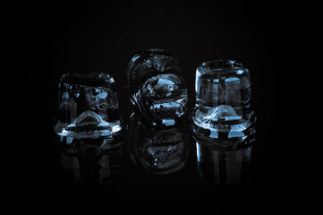 Ice cubes on black reflective background.